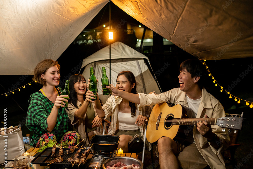 Travel Group of Diverse People Enjoy Camping Tent clinking beer bottles  with Friends, Hang Out Party campsite, Summer Travel and Recreation Concept.