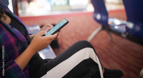 Woman waiting for departure at the airport on your vacation hold passport and smartphone while waiting boarding on departure area International Airport