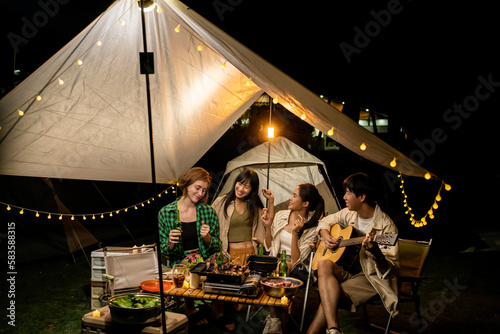 Travel Group of Diverse People Enjoy Camping Tent clinking beer bottles with Friends, Hang Out Party campsite, Summer Travel and Recreation Concept.
