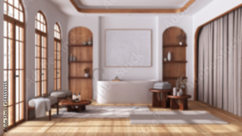 Blurred background, bathroom in boho style with arched windows and parquet. Freestanding bathtub, carpet and side tables. Japandi wooden interior design