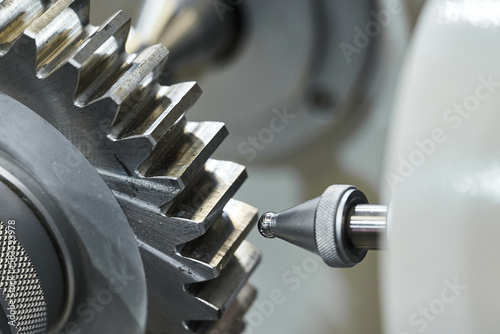 Canvas Print Grey cogwheel and oil nozzle in manufacturing workshop
