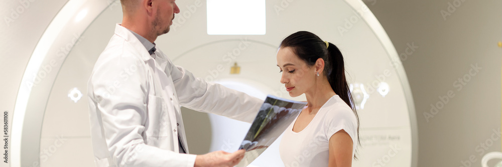 Doctor looks at MRI scan of woman in hospital Doctor looks at MRI scan of woman in hospital