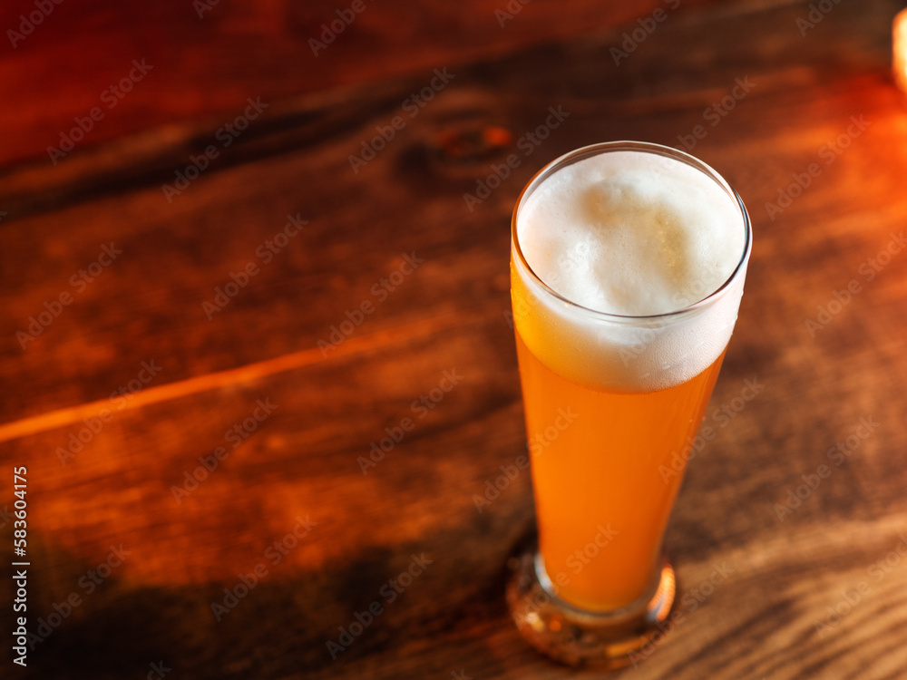 Glass of wheat german beer on wooden table