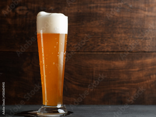 Glass of wheat german beer on wooden table