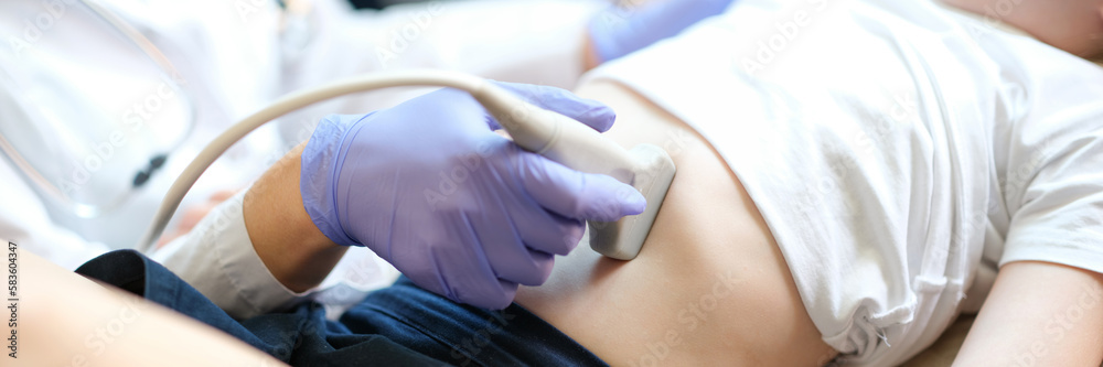Sonographer moves transducer on little girl belly