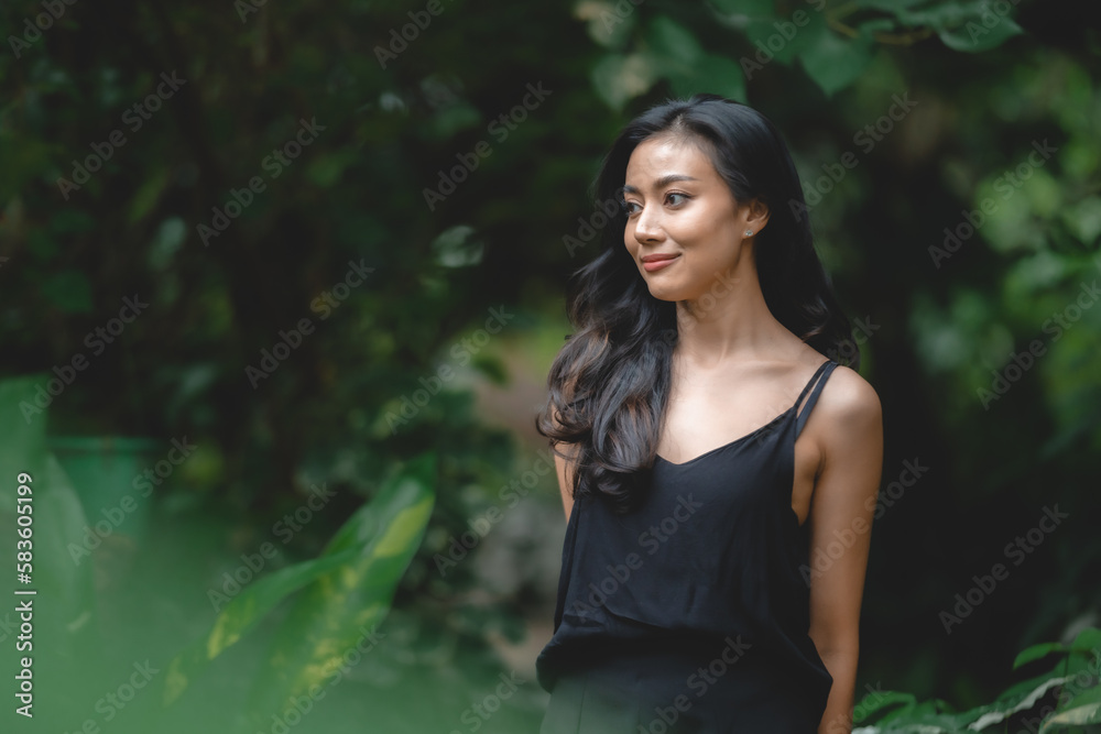 Beautiful girl in the garden on a sunny day, sexy Asian woman wearing black dress and posing to take a portraits photo, Art fashion spring model girl in day home forest, nature outdoor scene Beautiful girl in the garden on a sunny day, sexy Asian woman wearing black dress and posing to take a portraits photo, Art fashion spring model girl in day home forest, nature outdoor scene