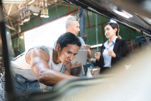 Vehicle automotive service guy worker doing check or mend car wheel, Asian mechanic repairman look under car condition to work in inspection workshop or maintenance to repair car engine in garage