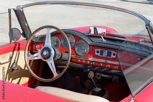 Dashboard of an old italian classic car . Particular view of steering wheel and vehicle instrument panel