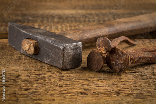 Vintage hammer with nails on wood background