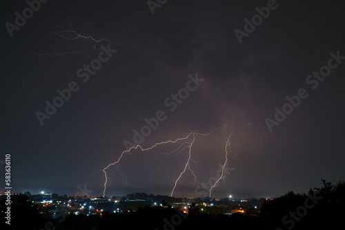 Bright lightning bolts over the commercial and urban area of Kempton Park. The unpredictability of Mother nature at its best. Thunder forming behind a formation of clouds and striking the earth.