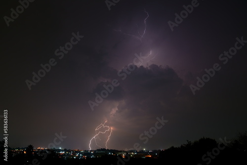 Bright lightning bolts over the commercial and urban area of Kempton Park. The unpredictability of Mother nature at its best. Thunder forming behind a formation of clouds and striking the earth.