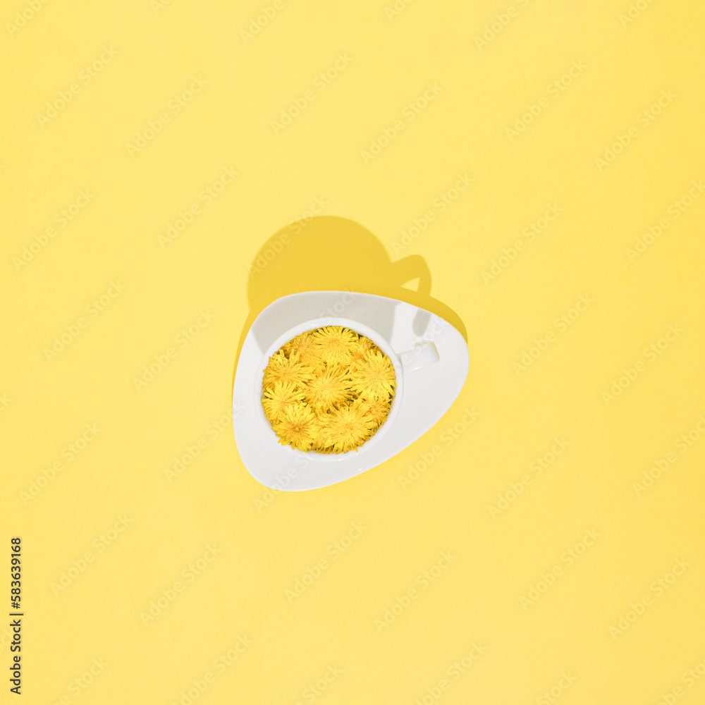 A cup of dandelion coffee on a sunny and yellow background. Minimal flat lay concept. A cup of dandelion coffee on a sunny and yellow background. Minimal flat lay concept.