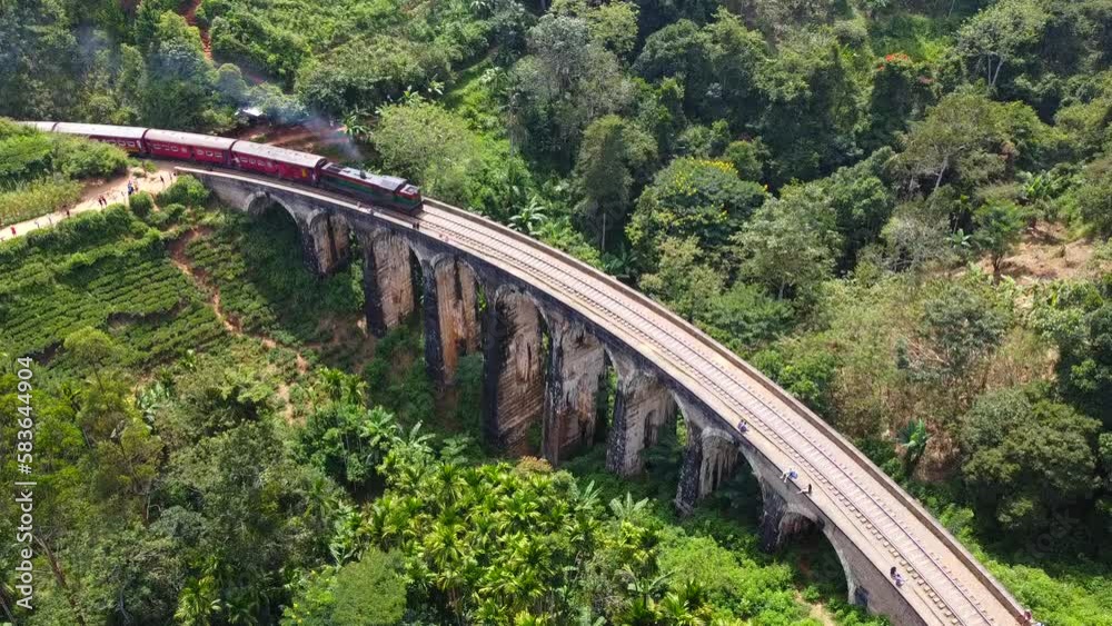 Aerial view of the old architectural nine-arch bridge in Sri Lanka with a train traveling on rails. Calm beautiful video on the background for tourism, design and advertising. Aerial view of the old architectural nine-arch bridge in Sri Lanka with a train traveling on rails. Calm beautiful video on the background for tourism, design and advertising.