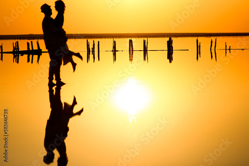 A happy couple at sea with water reflection silhouette background