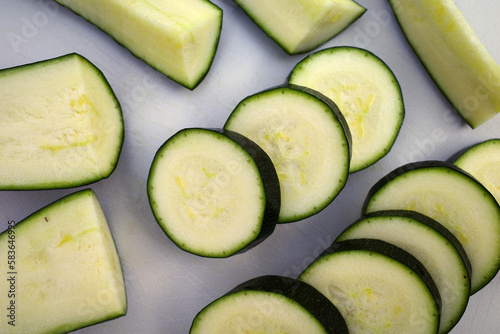 Cut ​​zucchini, lengthwise and sliced on a white cutting board