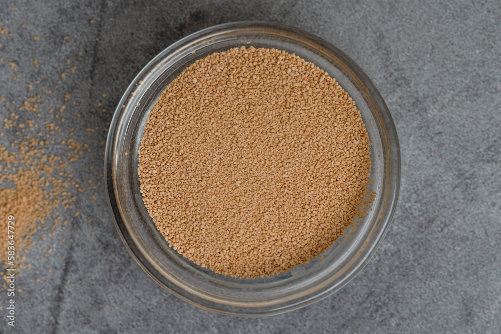 Dry yeast in a glass bowl close up on grey marble background, flat lay, copy space. Baking process, recipe Dry yeast in a glass bowl close up on grey marble background, flat lay, copy space. Baking process, recipe