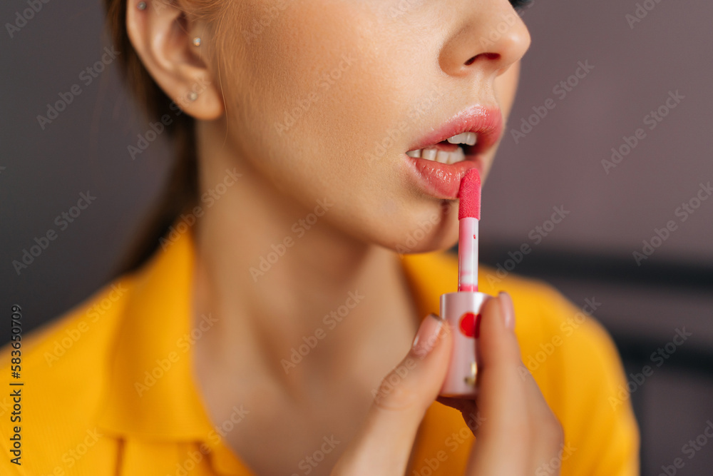 Close-up cropped shot of unrecognizable sensual woman with red hair applying lipstick holding mirror and looking at herself. Close up of beauty female looking facial at mirror for makeup cosmetic. Close-up cropped shot of unrecognizable sensual woman with red hair applying lipstick holding mirror and looking at herself. Close up of beauty female looking facial at mirror for makeup cosmetic.