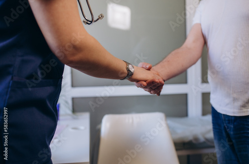 Male doctor holding hands to encourage senior patient and explaining healthcare for elderly after physical his health checkup and writing prescription on clipboard in hospital.