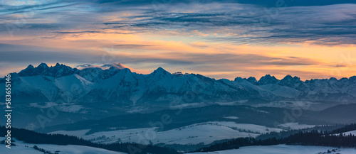 winter panorama of the Tatras against the background of the orange sky
