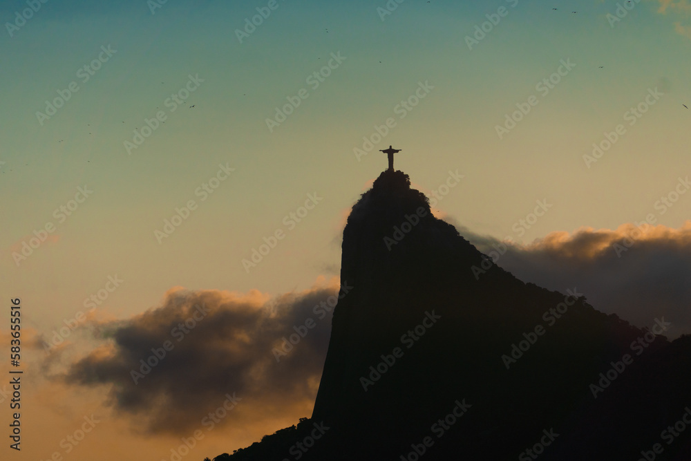 Sunset in the bay of Guanabara, cove and beaches of Rio de Janeiro, Brazil with its buildings, boats and landscape. Christ the Redeemer on top of Corcovado. Reflection of the sky in the sea