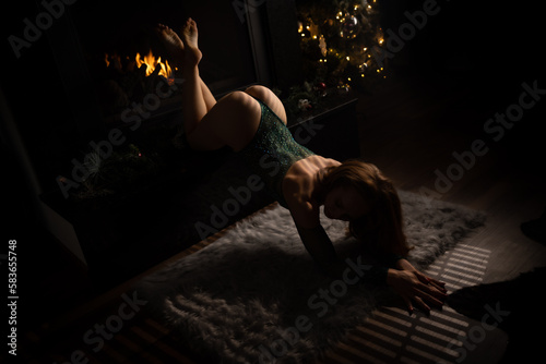 women crawling off of fireplace mantle by Christmas tree