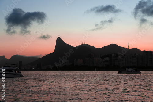 Sunset in the bay of Guanabara  cove and beaches of Rio de Janeiro  Brazil with its buildings  boats and landscape. Christ the Redeemer on top of Corcovado. Reflection of the sky in the sea