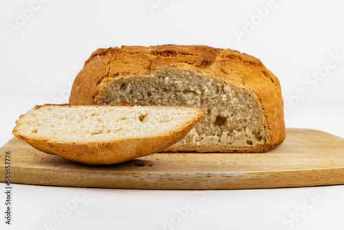 Delicioso pan casero recién horneado, con rebanada sobre madera y aislado sobre fondo blanco. Serie