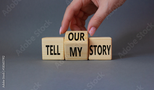 Tell our or my story symbol. Businessman hand turns wooden cubes and changes the words Tell my story to tell our story. Beautiful grey background. Business concept. Copy space photo