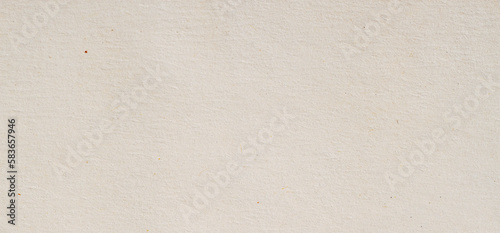 Light background of cardboard from natural paper with non-smooth, rough texture, small inclusions of cellulose