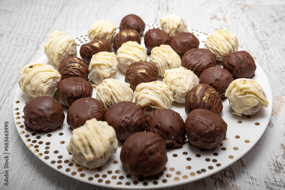 Chocolate truffles on plate on white table. Homemade. Praline bonbons.