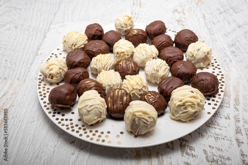 Praline bonbons. Chocolate truffles on plate on white table. Homemade.