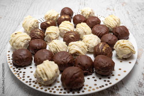 Obraz na płótnie Chocolate truffles on plate on white table. Homemade. Praline bonbons. w salonie