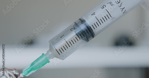 The doctor dials an antibiotic from a glass ampoule into the syringe. Macro shooting. Needle syringe with medicine. Antibiotic injections. High quality 4k footage