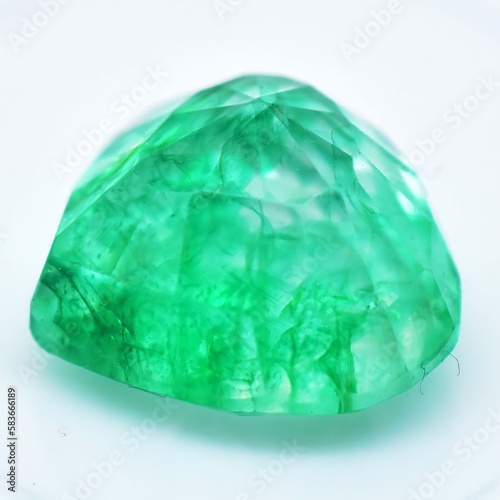 Natural gemstone green emerald on gray background
