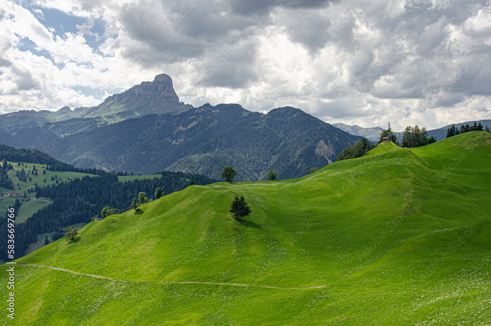 Rolling green meadows above La Val village with Sass de Putia mountain, Alta Badia, Dolomites, South Tyrol, Italy