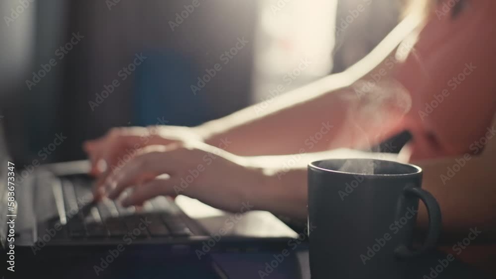 Close-up of female hands making friends on a laptop and a cup of coffee. The girl has been working online from home since morning. Home office with tea. High quality 4k footage Close-up of female hands making friends on a laptop and a cup of coffee. The girl has been working online from home since morning. Home office with tea. High quality 4k footage