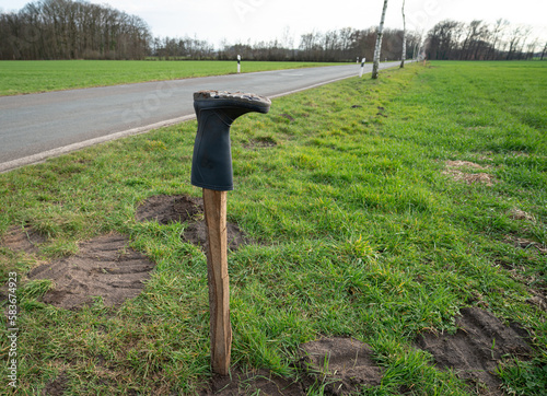 Auf einem Holzpfahl gestülpter Gummistiefel als Zeichen des Widerstandes der Landwirtschaft gegen die Agrarpolitik. photo