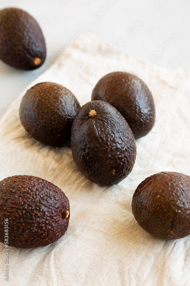 Raw Organic Hass Avocados on a gray background, side view. Raw Organic Hass Avocados on a gray background, side view.