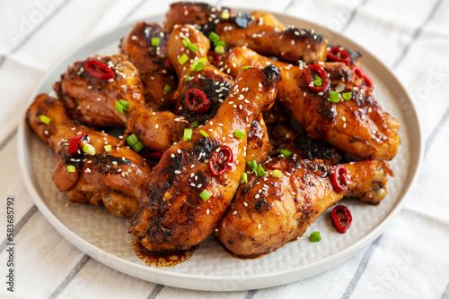 Homemade Easy Sticky Chicken Drumsticks on a Plate, low angle view. Close-up.