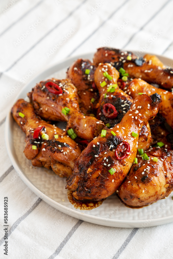 Homemade Easy Sticky Chicken Drumsticks on a Plate, side view. Close-up.