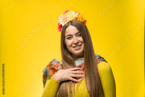 Portrait of a smiling young woman on a yellow background.