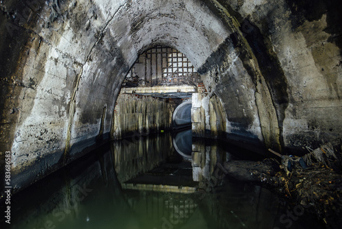 Flooded underground urban sewer tunnel. Large sewage collector