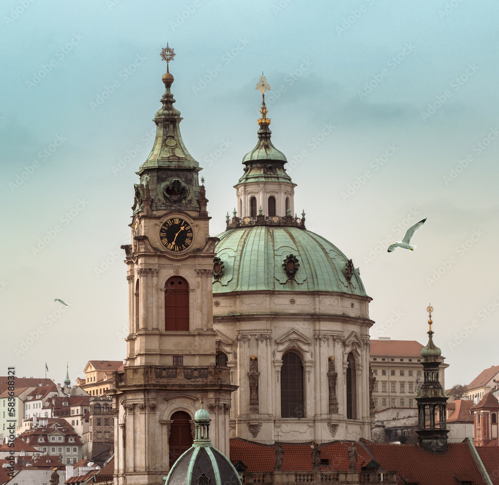 Cityscape of Prague with St Nicholas Church and Bell Tower with Clock in Lesser Town. Religious architecture in Baroque style, old buildings and city landmark in historic downtown of Praga.