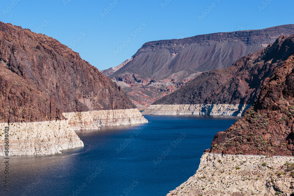 The Colorado River with rocky cliffs on both sides as it leads up to Hoover Dam.