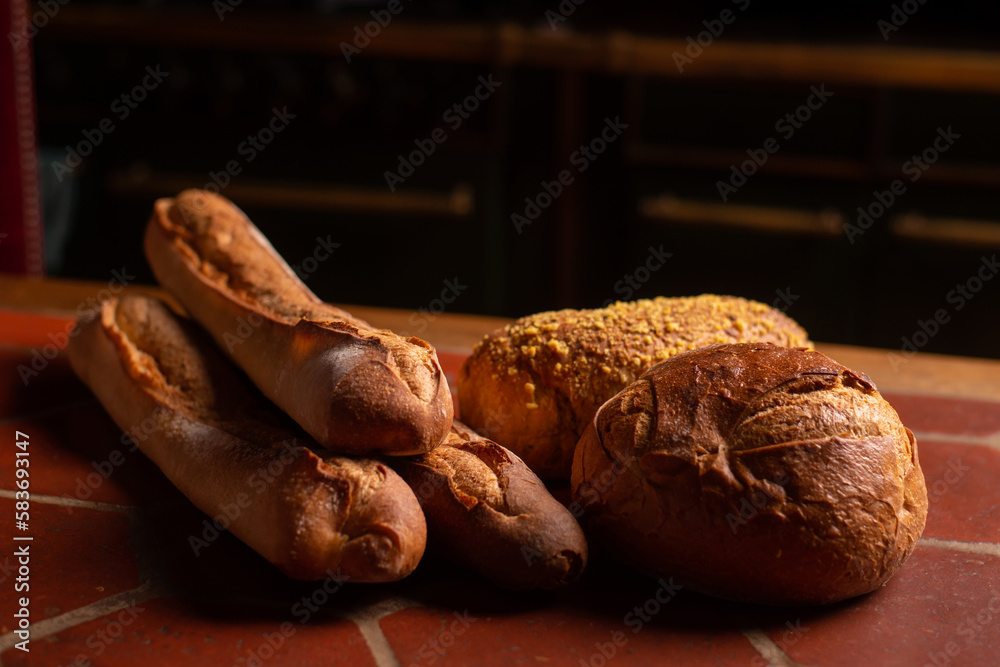 Different types of french bread on the table. Baguettes, round bread with bran. Copyspace.
