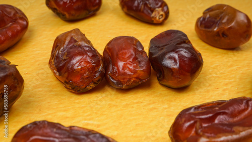 Kurma or dried dates on yellow background. selective focus