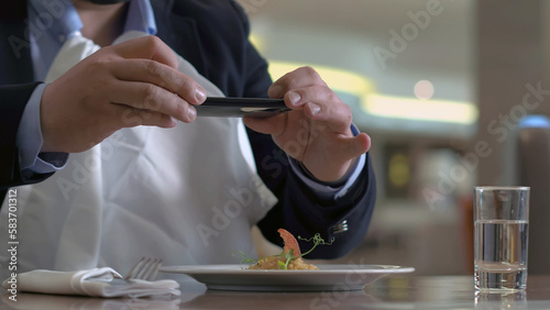 Hungry man rubbing hand before eating, taking napkin and making photo food on