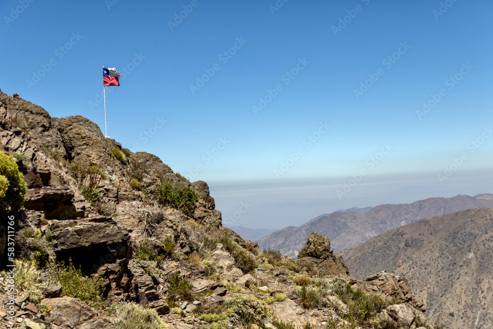 Fototapeta premium Chilean flag at Refugio Aleman in the Andes at Yerba Loca Nature Sanctuary in Chile