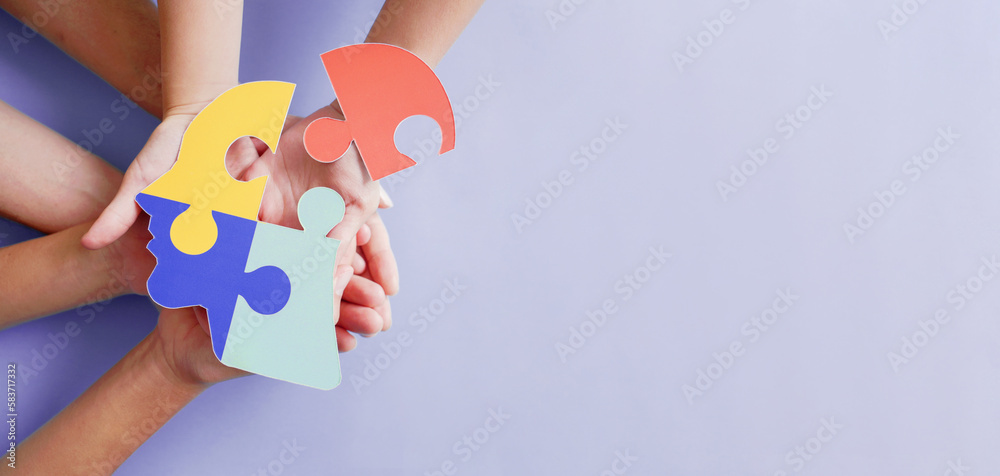 Hands holding jigsaw puzzle head shape, Autism awareness, Autism spectrum disorder (ASD), World Autism Awareness Day - obrazy, fototapety, plakaty 