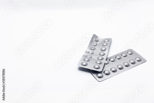 Two plastic blister-wrapped medicines is crumpled on a white background. Several packages of medicine are ripped off and there is a lot of empty space and copy space on one side.